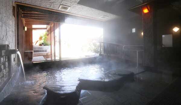 湯けむり漂う岩風呂、窓からの眺めをお楽しみください！