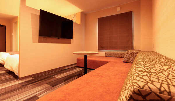 ・【プレミアDXファミリー】リビングルームの大きなソファはベットとしてお使いいただけます