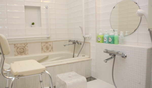 1号室　バスルーム内　浴室スペース　浴槽周りの壁に手摺有り　腰掛けイス（オプション）