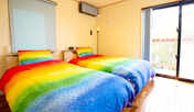 ・＜寝室一例＞寝具も鮮やかなレインボーで明るい雰囲気の寝室