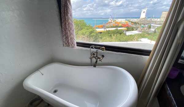 バスルームです。猫脚のバスタブをご用意しました。平良港を一望できます。