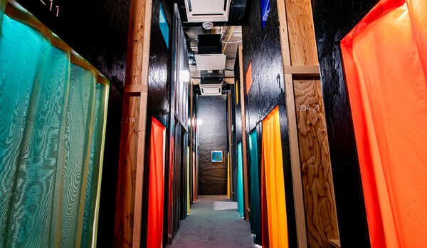 カラフルなカーテンに囲まれたカプセルルーム