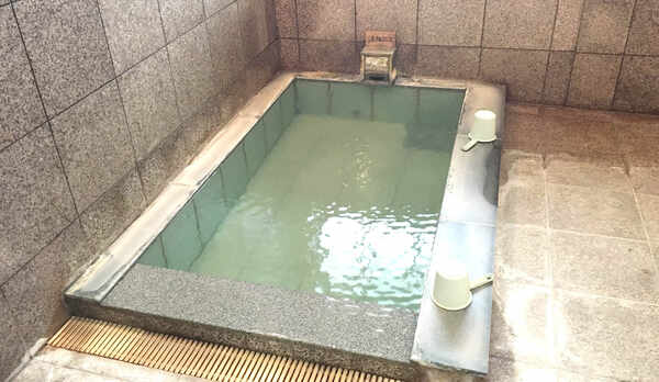 ・＜女湯＞ピンクタイルを基調としたお風呂です。日によって湯花の量が違うため、濁り方が変わります