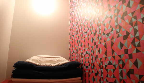 鍵付き扉と壁で仕切られたシングルカプセルルーム上段