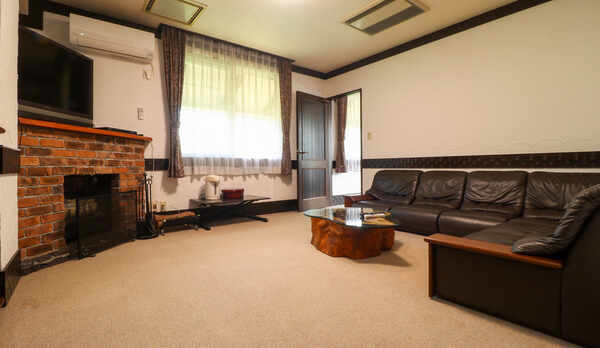 スイート　リビングにソファーと暖炉がある広々としたお部屋です。