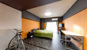 ・＜サイクルルーム　ダブル一例＞オレンジを基調としたシンプルな内装