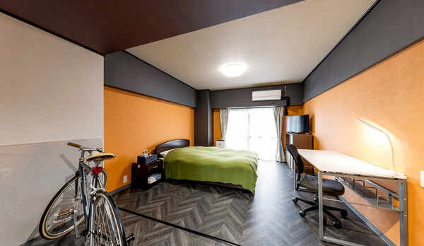 ・＜サイクルルーム　ダブル一例＞オレンジを基調としたシンプルな内装