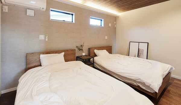 木の温もりを感じるツインベッドの寝室。