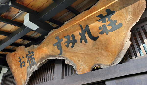 すみれ荘玄関には、木のぬくもり感じる看板が