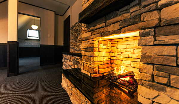 【本館ツイン】余裕のある室内には石造りの暖炉（イミテーション）をそなえ、落ち着いた大人の雰囲気。