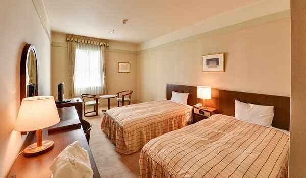 *【スタンダードツイン一例】白を基調にブラウンの家具が配置されたくつろぎの空間（温泉ユニットバス付）