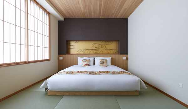 クイーンルーム（バスタブ）/ 大胆にデザインされたベッドサイドの装飾は、職人の技を間近に体感できます