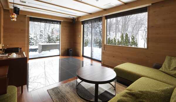 ◆スパリビング付ツインルーム（冬）／大きなソファで寛げるリビング。隣には温泉スパルームが（客室一例）