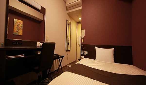 落ち着いたデザインのコンフォートシングルルーム。お部屋にはズボンプレッサーも常備しております。