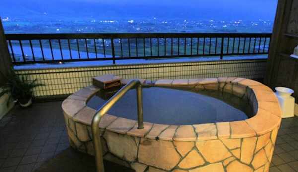 【露天風呂和洋室】筑後平野を眺めながら、石張り風呂で温泉をお楽しみいただけます。