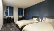 スタイリッシュな青い壁紙のツインルーム。空港近くビジネスにも最適。