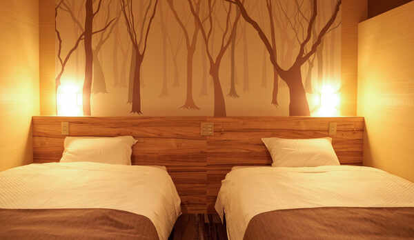 ・【プレミアDXファミリー】コンセント付きのヘッドボード。充電しながらスマホをお使いいただけます